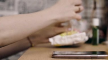 Kız ıslak mendille telefonu siler.