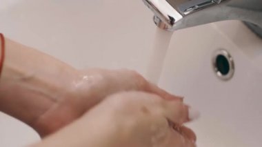 Kız banyoda yemek yemeden önce ellerini yıkar.