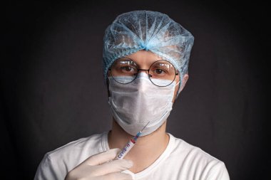 Laboratuvarda bir doktor ya da bilim adamı COVID-19 Coronavirus testlerinin yapıldığı bir şırınga tutuyor.