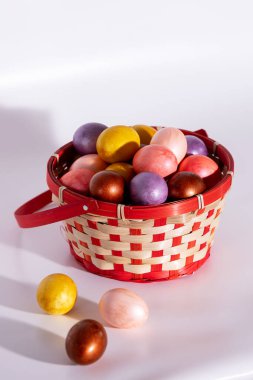 Paskalya boyalı yumurtalar beyaz sepete izole edilmiş.