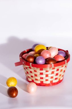 Paskalya boyalı yumurtalar beyaz sepete izole edilmiş.