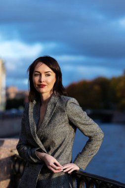 Gri takım elbiseli güzel kadın Saint-Petersburg 'da gezinti güvertesinde yürüyor.