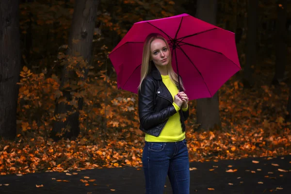 Portrait of a young beautiful girl close up under the pink umbrella in rainy autumn weather in the park — Stock Photo, Image