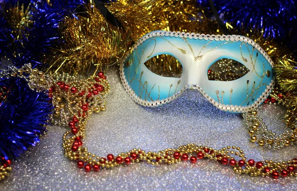 Brilliant blue carnival mask close up on shiny background with festive colored garlands — Stock Photo, Image