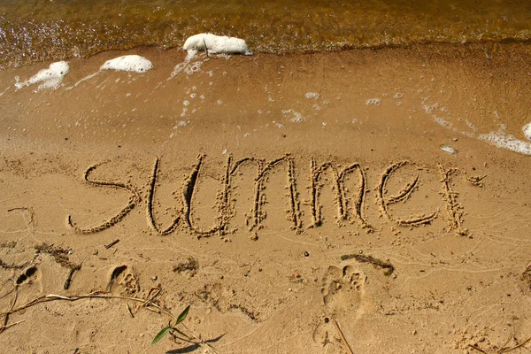 Το καλοκαίρι επιγραφή πάνω στην άμμο δίπλα στη θάλασσα με τα κύματα — Φωτογραφία Αρχείου