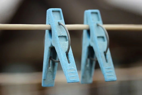 Twee blauwe wasknijpers close-up opknoping op een touw om kleren te drogen — Stockfoto