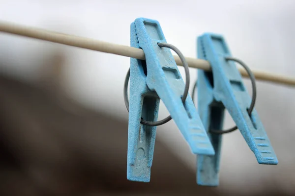 Twee blauwe wasknijpers close-up opknoping op een touw om kleren te drogen — Stockfoto