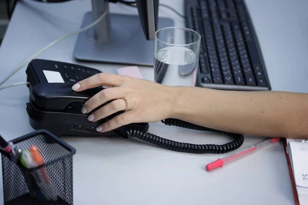 Hands of a young woman close-up on the phone in the office — Stock Photo, Image