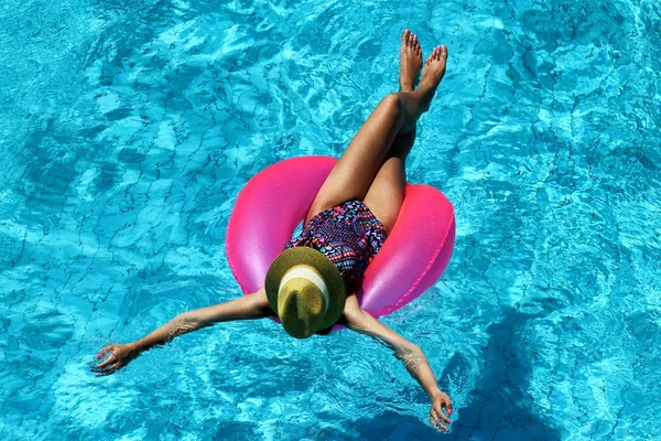 Ung vacker flicka simning i poolen med en rosa cirkel — Stockfoto