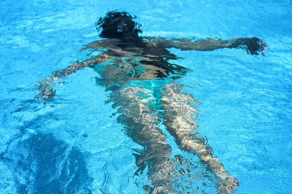 Menina bonita nova nadando debaixo de água na piscina com água azul — Fotografia de Stock