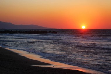 Deniz kenarında güzel pembe günbatımı yaz büyük portakal güneş ile içinde.