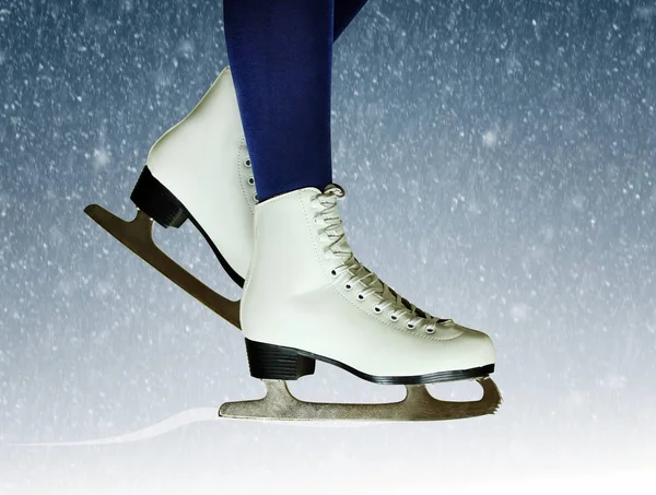 Female figure skates close-up on a snowy New Years background. Winter skating background