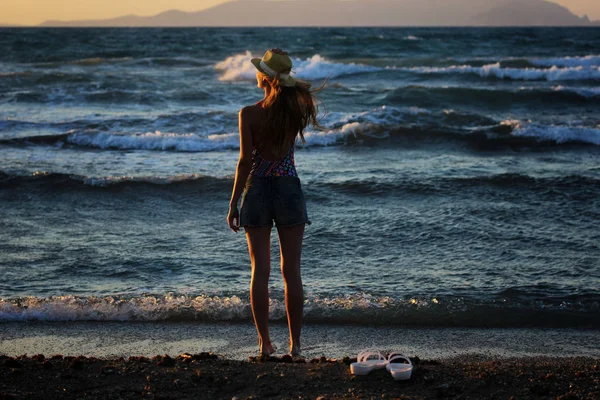 Joven hermosa chica atractiva de pie cerca del mar al atardecer en verano — Foto de Stock