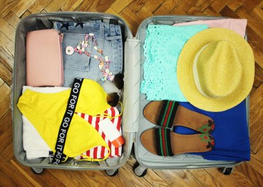 Toplanan bavul seyahat için. Açık görünüm portre bir ahşap arka plan üzerinde dinlenmek şeylerle çantada