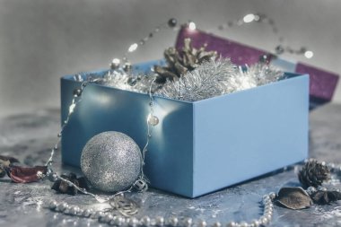 Gri arka planda parlak ışıklarla süslenmiş muhteşem bir hediye kutusu..