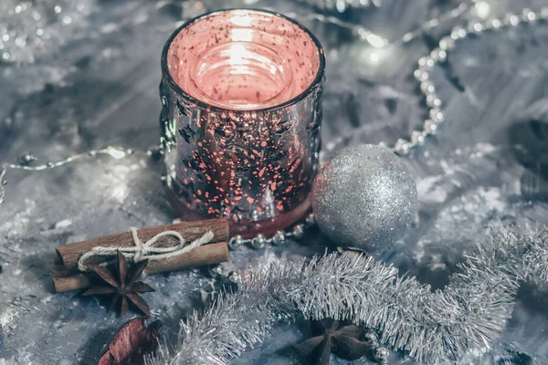 Castiçal brilhante com uma vela ardente em um fundo de prata com decorações festivas. Plana lay card — Fotografia de Stock