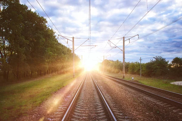 The railway lines and rails close-up near the railway station in sunset time