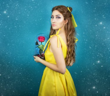 Sarı uzun elbiseli güzel kadın ellerinde kırmızı gülle yakın plan. Güzellik ve canavar kostüm sanat işleme