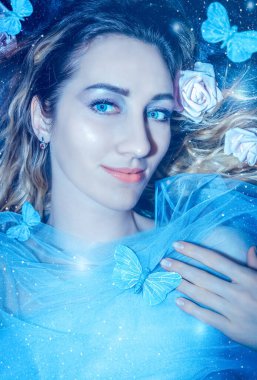 Mavi kelebekleri ve sihirli ışığı olan gizemli orman arka planında genç ve güzel bir kadın..