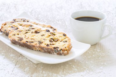 Kahve ile beyaz bir plaka üzerinde taze Noel Stollen