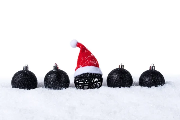 Cinco bolas de Navidad Negro con nieve y Santa Sombrero aislado sobre fondo blanco —  Fotos de Stock