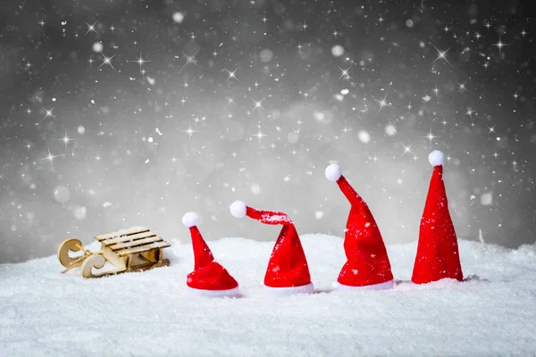 Fondo gris de Navidad con Santa Sombreros y trineo en la nieve —  Fotos de Stock