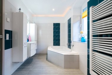 Modern banyo - parlak beyaz ve mavi karolar - küvet, lavabo ve yerden ısıtma yatay atış