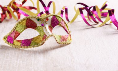 Kağıt flama üzerinde parlak tahta arka plan ile Venedik karnaval maskesi