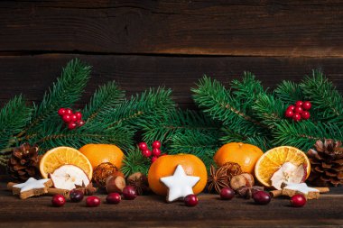 Tahta arka planda fidan dalı ve tarçınlı kurabiye ve mandalina