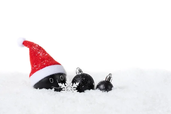 Baumle de Navidad negro con Santa Sombrero sobre nieve sobre fondo blanco —  Fotos de Stock