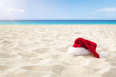 Beyaz kumlu bir Karayip plajında Noel Baba şapkasını kapat. Noel Tatili Seyahat Konsepti
