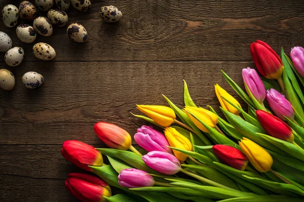 Creative arrangement of tulips and quail eggs on rustic wooden background for March 8, International Womens Day, Birthday , Valentines Day or Mothers day - Closeup - Flat lay.