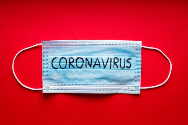 Coronavirus - 2019-nCoV, concepto de virus WUHAN. Máscara quirúrgica máscara protectora sobre fondo rojo. Brote de virus de la corona china . —  Fotos de Stock