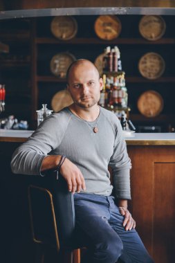 bir barda oturan yakışıklı adam