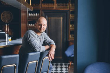 bir barda oturan yakışıklı adam