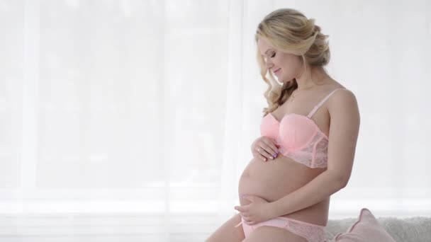 Mulher grávida em lingerie acaricia sua barriga. Futura mãe — Vídeo de Stock