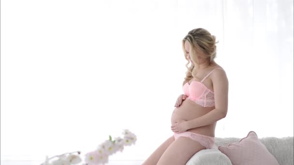 Kobieta w ciąży w bieliźnie pieszczoty jej brzuch. Mama przyszłości — Wideo stockowe