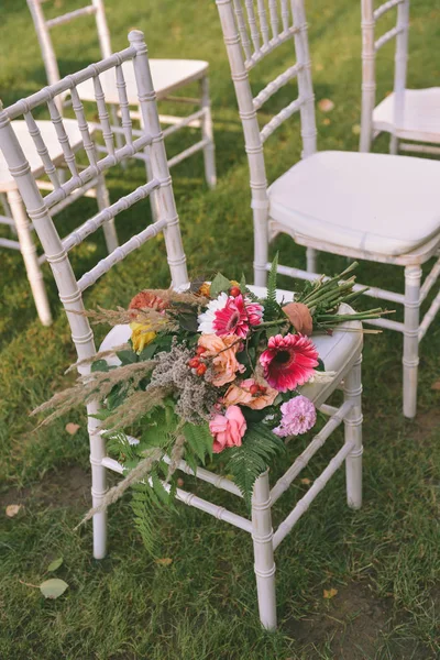 Bouquet de mariage d'automne repose sur une chaise — Photo