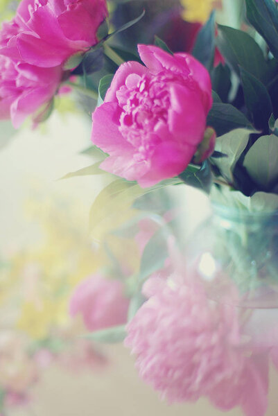 A bouquet of peonies in a glass vase, a soft focus, a watercolor blurry style. background