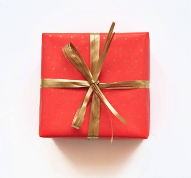 Beyaz zemin üzerine altın fiyonklu kırmızı hediye.