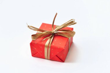 Beyaz zemin üzerine altın fiyonklu kırmızı hediye.