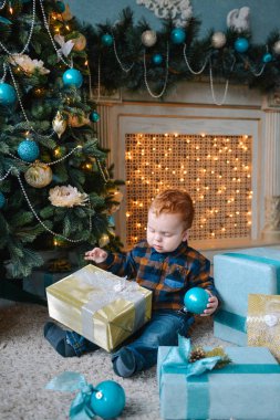 kutuları oturan ve Noel açma küçük çocuk sunar