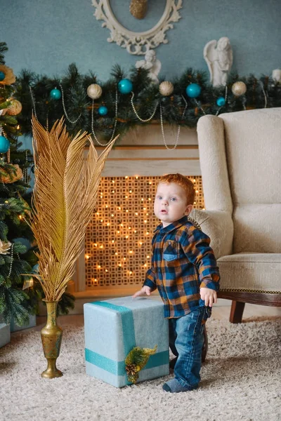 Petit garçon debout près des boîtes avec des cadeaux de Noël — Photo