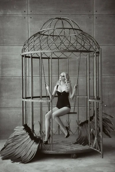 Блондин жінка, з чорними крилами в клітці. Ангел, Містика — стокове фото
