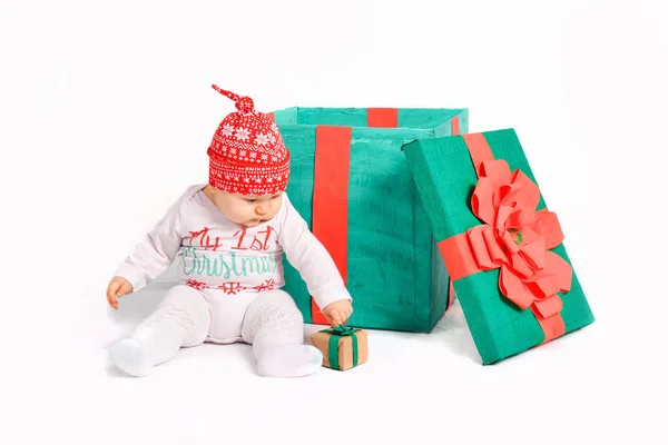 Bébé dans un costume de Noël est assis avec des cadeaux. beaux cadeaux du Nouvel An — Photo