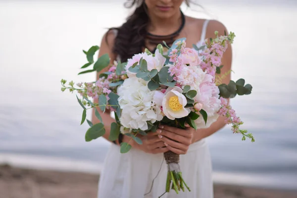 Bride holding her boho wedding bouquet.