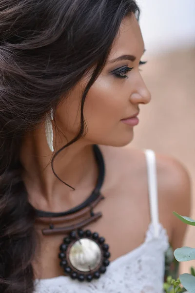 Sahilde oturan beyaz elbiseli kadın. Gelin Boho tarzı