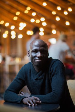 Karanlık bir odada oturan yakışıklı adam. gülümseme portre