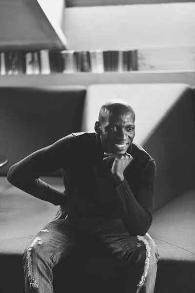 Un bel homme assis dans une pièce sombre. sourire portrait — Photo