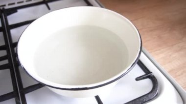 Paskalya yumurtalarını kaynar suyun üzerine boyarken kadınların elleri mutfakta zebranın hayvan desenli bir çıkartmasını yırtıyor.
